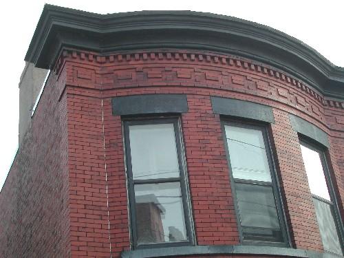 This photograph shows the cornice and the upper storey of the rounded bay window, 2005.; City of Saint John