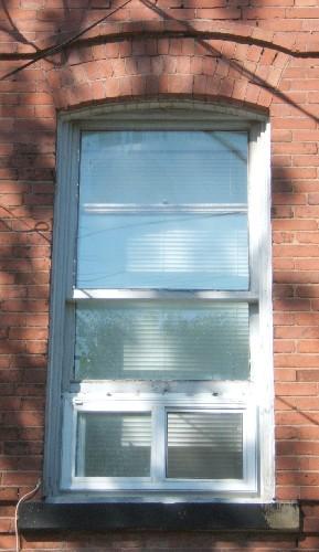 This image shows one of the segmented arched windows of the upper storeys, 2005.; City of Saint John