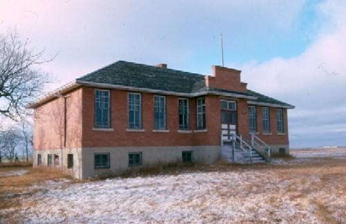 View of the school at the Pheasant Forks Heritage Site featuring the brick walls and massing, 1985.; Government of Saskatchewan, G. Pugh, 1985