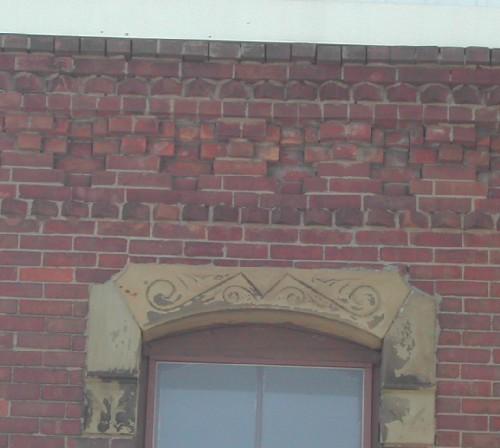 This photograph shows the cornice and a decorative sandstone lintel, 2005.; City of Saint John