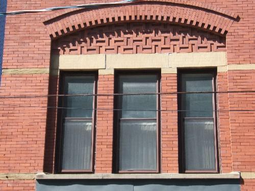 This photograph shows the triple window under a segmented arch, 2005.; City of Saint John