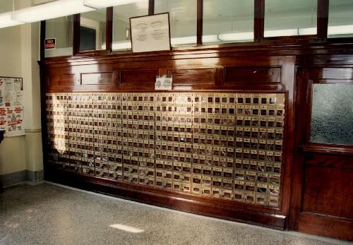 Interior view of the Government of Canada Building in North Head, showing the original panelled wooden wickets, 1993.; Public Works and Government Services Canada / Travaux publics et Services gouvernementaux Canada, 1993.