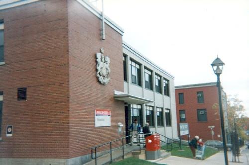 Corner view of the Government of Canada Building, showing the main entrance and side façade, 1995.; Agence Parcs Canada / Parks Canada Agency, 1995.