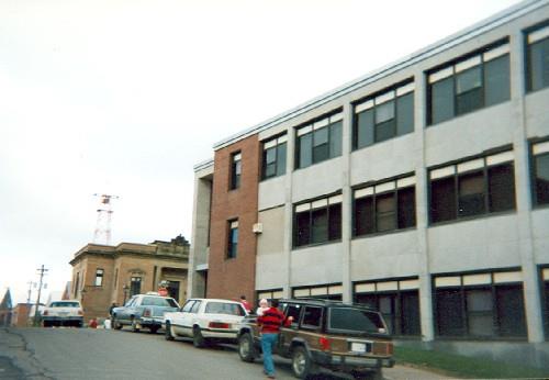 Side elevation of the Government of Canada Building, showing the brick walls with sandstone trim and the strip windows, 1995.; Agence Parcs Canada / Parks Canada Agency, 1999.