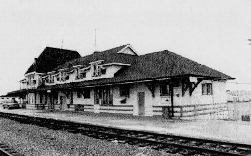 Track view, showing the roof of the one-storey portion of the station that extends around the building creating wide bracketed eaves on the trackside and over the street side entrance, 1991.; Agence Parcs Canada / Parks Canada Agency, 1991.