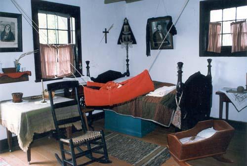 Interior view of Louis Riel House, showing an interpretation of the house in mourning in 1886, 1999.; Parks Canada Agency / Agence Parcs Canada, 1999.