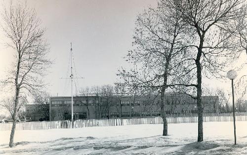 Front elevation of the Queen Building, showing its low, horizontal massing and asymmetrically placed entrance block, 1997.; Parks Canada Agency / Agence Parcs Canada, 1997.