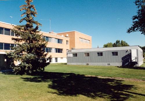 Side view of Building 84, showing its flat roof, horizontal bands of windows, and absense of decoration, 1996.; Department of National Defence / Ministère de la Défense nationale, 1996.