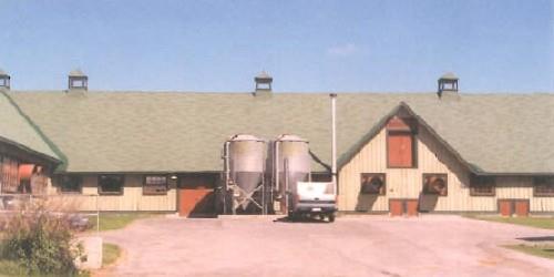 South elevation of the Swine Showcase Building No. 91, showing the utilitarian medium-pitched roof with large dormers and roof ventilators, 1995.; Agence Parcs Canada / Parks Canada Agency, Cosimo Zacconi, 1995.