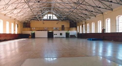 Interior view of the Armoury, showing the large open volume of the drill hall with exposed steel trusses and expansive glazing, 1994.; Parks Canada Agency / Agence Parcs Canada, 1994.