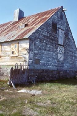 Corner view of Hebron Mission, showing the stone foundation and the steep roof, 1994; Parks Canada Agency / Agence Parcs Canada, I.K. MacNeil, 1994.