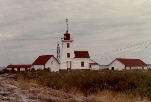 Side view of the Lighthouse and Dwelling on Gereaux Island, showing the three-storey, square, tapered form of the tower and the attached gable-roofed dwelling that is well integrated with the tower, 1981.; Parks Canada Agency / Agence Parcs Canada, 1981.