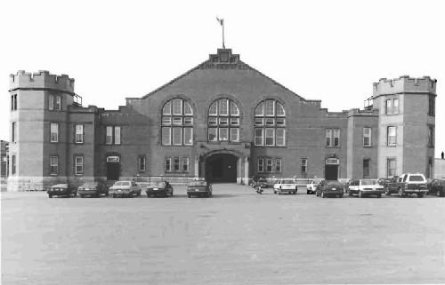 General view of the Barrack Green Armoury, showing its octagonal, crenellated corner towers, 1990.; Ministère de la Défense nationale / Department of National Defence, 1990