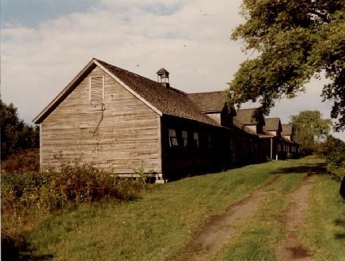 Corner view of Building 100, showing the four large dormers on the south slope of the roof.; Agence Parcs Canada / Parks Canada Agency