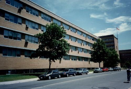 Side elevation of the Chemical Radioactive Ores Building, showing the bands of aluminium-framed windows with prominent stone sills and projecting overhead brises-soleil.; Agence Parcs Canada / Parks Canada Agency.