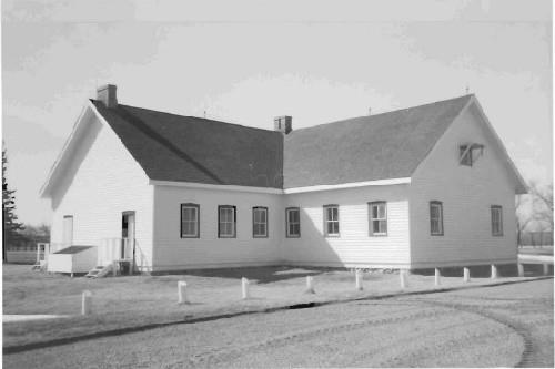 Side elevation of the Barracks No. 5, showing the simple, single-storey massing of the T-shaped building, 1989.; Agence Parcs Canada / Parks Canada Agency, 1989.