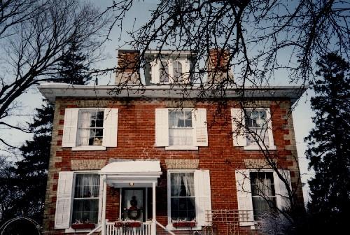 Rear view of Bentley House, showing the exterior walls of red brick with contrasting pale brick for window trim and corner quoins, 1992.; Public Works and Government Services Canada / Travaux publics et Services gouvernementaux Canada, 1992.