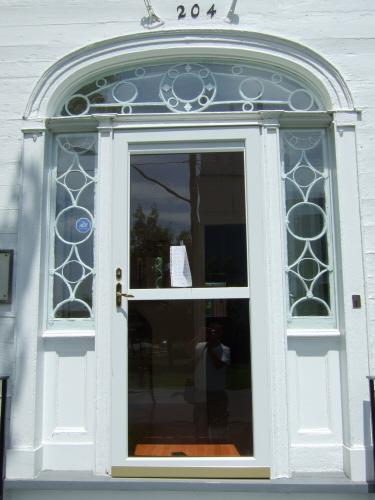 This photograph shows the handsome Neo-classical entrance with circular and diamond pattern in the fan window and sidelights, 2007.; Town of St. Andrews