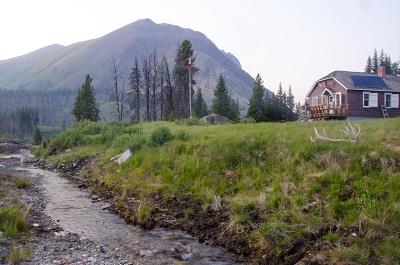 Corner view of the Windy Lodge Warden Cabin, showing the wooden deck, ca. 2018.; Parks Canada Agency / Agence Parcs Canada, ca./vers 2018.