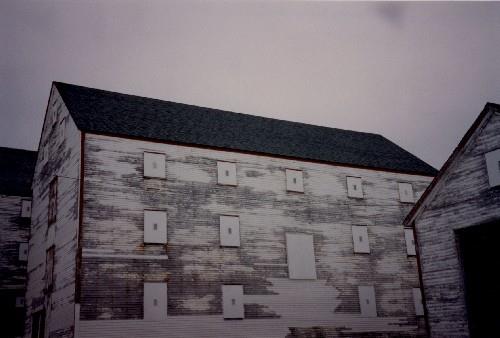 Side elevation of Ryan Fish Storage, showing the clapboard walls that are outlined by finely proportioned trim, 1993.; Agence Parcs Canada / Parks Canada Agency, 1993.