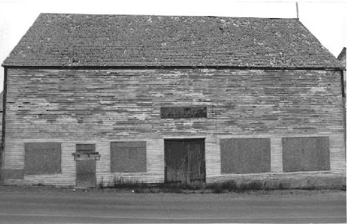 Side elevation of the Ryan Store and Fish Purchasing Centre, showing the clapboard walls that are outlined by finely proportioned trim, and by the slight eaves overhang and the narrow fascia, 1991.; Agence Parcs Canada / Parks Canada Agency, 1991.