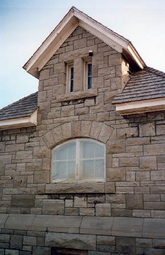 Side view of the Maintenance Building, showing the stone walls, built up in irregularly coursed rough-cut limestone, 1988.; Parks Canada Agency / Agence Parcs Canada, 1988.