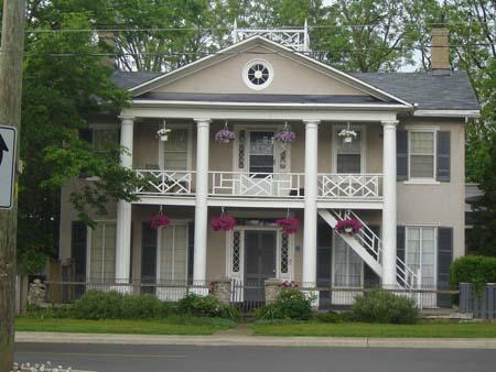 Of note are the Doric columns, bull's eye window in the attic gable and low balustrade.; Kayla Jonas, 2007.